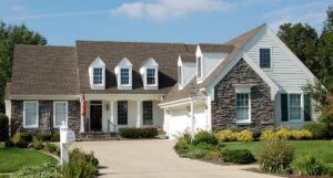 A sunlit great room with high ceilings, large windows, and a view of a screened pool and lanai.